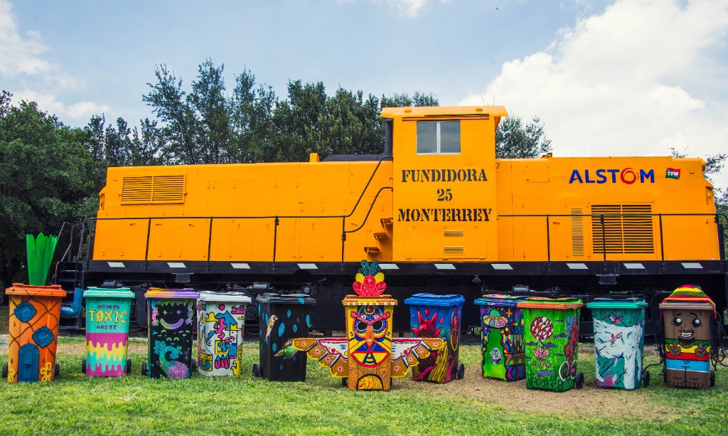 Painted bins in front of a yellow Fundidora locomotive